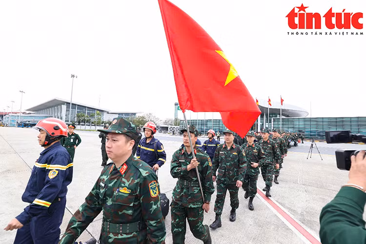 Lực lượng cứu hộ mang theo quốc kỳ Việt Nam, thể hiện tinh thần sẵn sàng hỗ trợ nhân đạo quốc tế.