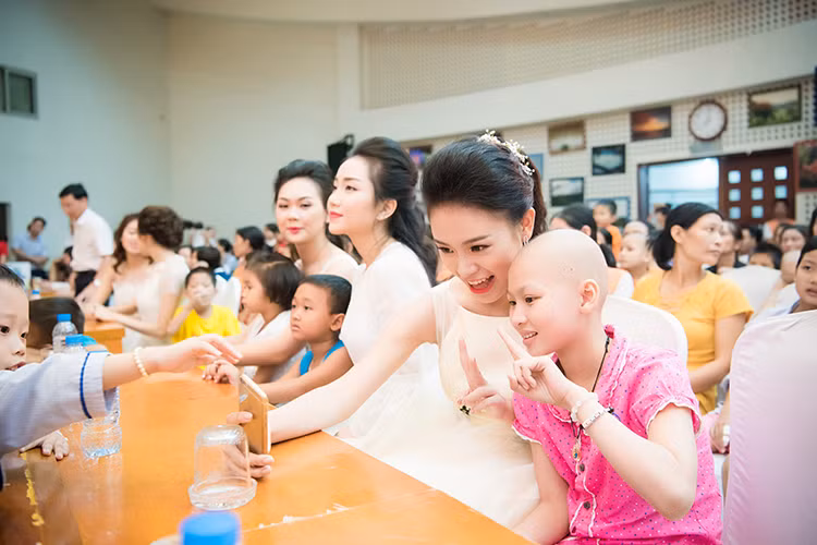“Người đẹp truyền thông” Phùng Bảo Ngọc Vân vui đùa cùng một trong số hơn 400 bệnh nhi ở Viện Huyết học - Truyền máu TƯ.