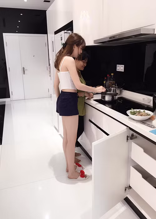 “Nữ hoàng nội y” Ngọc Trinh và mẹ kế có mối quan hệ rất thân thiết. Trong ảnh, cô vui vẻ phụ giúp mẹ kế nấu ăn.