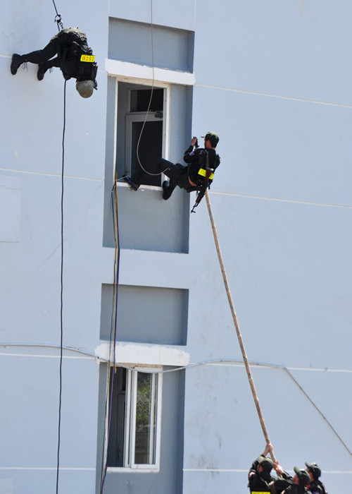 Cảnh sát dùng sào dài tạo thế đòn bẩy đưa chiến sĩ tiếp cận lầu cao - nơi nhóm khủng bố đang khống chế con tin. Nhóm khủng bố yêu cầu trong vòng một giờ Quảng Ngãi phải đáp ứng các yêu sách, nếu không các con tin sẽ bị giết chết. 