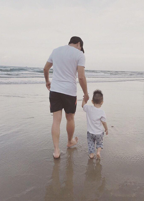 Bé Benjamin nắm chặt tay bố trong chuyến du lịch vào cuối tháng 8 vừa qua. 