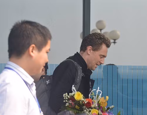 Tài tử Tom Hiddleston ôm bó hoa tươi thắm vừa nhận từ các nhà lãnh đạo.