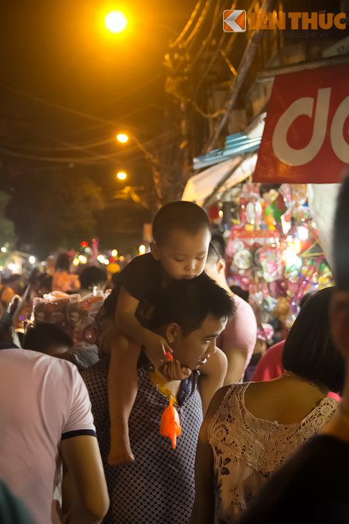 Trẻ nhỏ được bố mẹ dẫn đi dạo phố.