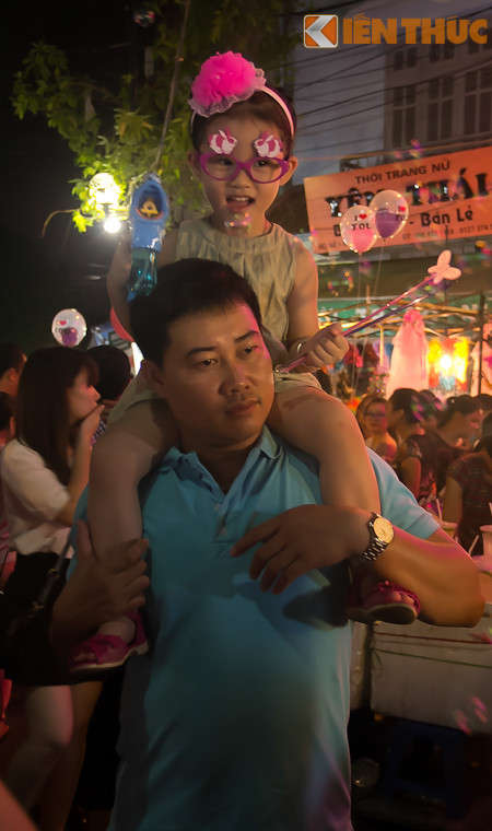 Để các cháu nhỏ không bị chèn ép trong cảnh phố đông người và có thể ngắm nghía xung quanh, nhiều vị phụ huynh chọn cách kềnh con lên cổ.