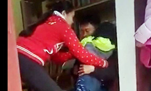 Hình ảnh người phụ nữ đòi bế cháu bé nhưng cháu nhỏ nhất mực không theo.