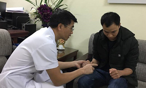 PGS.TS Lê Văn Đoàn đang khám cho một bệnh nhân gặp chấn thương tay. Ảnh: Hà Quyên.