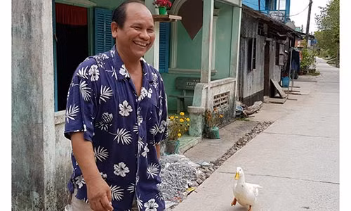 Ông Sơn Văn đi sang nhà hàng xóm thì chú vịt cũng lẽo đẽo theo sau. Ảnh: Việt Tường.