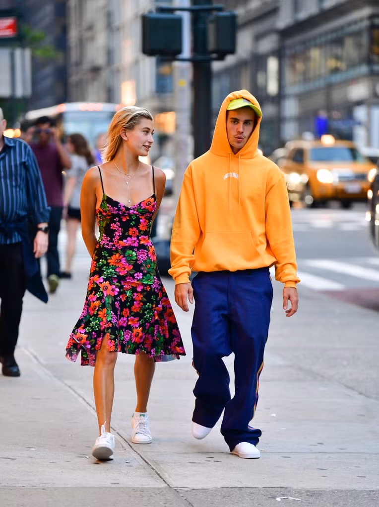 Một lần xuống phố, giọng ca As long as you love me diện hoodie nổi bật cùng quần thể thao xanh, có đường kẻ sọc vàng ton-sur-ton với áo. Ngoài ra, bộ đôi giày sneaker trắng và mũ lưỡi trai sắc neon giúp Bieber thêm phần trẻ trung, năng động.