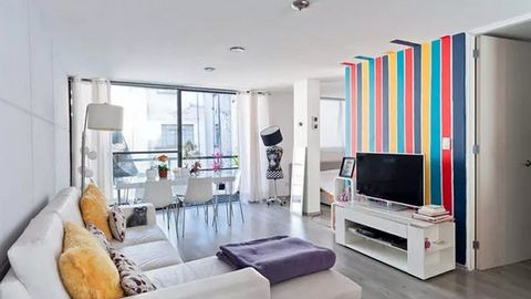 6. Kệ TV trắng trẻ trung hiện đại Ví dụ phòng khách trẻ trung đáng yêu rất dễ học tập. Tủ kệ TV truyền thống với mẫu mã hiện đại. Màu trắng thanh nhã nổi bật của ngôi nhà đẹp với nền background là thảm treo tường sặc sỡ màu.