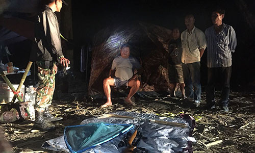 Ông Premchai Karnasuta ngồi trước lều trong công viên quốc gia khi bị cảnh sát kiểm tra và bắt giữ.