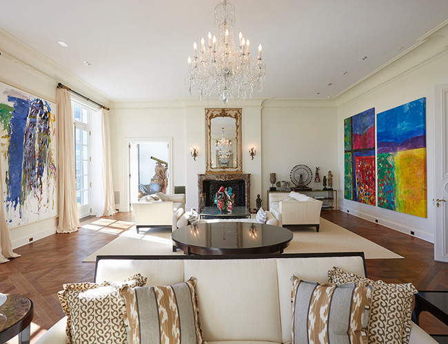 Đi vào bên trong, bạn sẽ thấy phòng khách được trang trí công phu với đèn chùm pha lê và lò sưởi bằng đá cẩm thạch mang phong cách sang trọng.