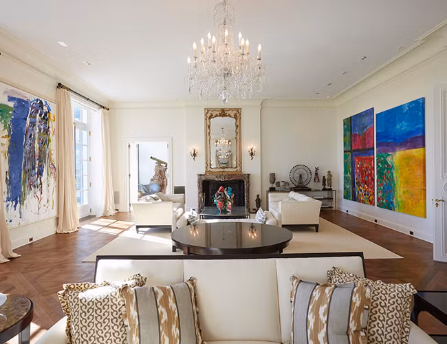 Đi vào bên trong, bạn sẽ thấy phòng khách được trang trí công phu với đèn chùm pha lê và lò sưởi bằng đá cẩm thạch mang phong cách sang trọng.