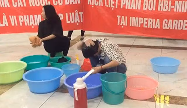 Gội đầu ở sảnh chung cư để phản đối chủ đầu tư.