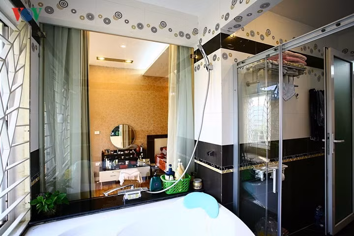 Mảng tường giữa phòng ngủ và phòng tắm được thay bằng vách kính. Sự kết nối này tạo nên nhiều điểm nhìn đẹp trong không gian.
