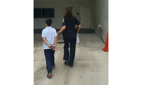 Hình ảnh cậu bé bị còng tay và dẫn đi giám định tâm thần trong bệnh viện - Ảnh chụp màn hình