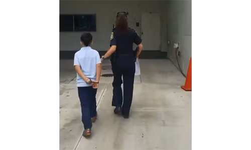 Hình ảnh cậu bé bị còng tay và dẫn đi giám định tâm thần trong bệnh viện - Ảnh chụp màn hình