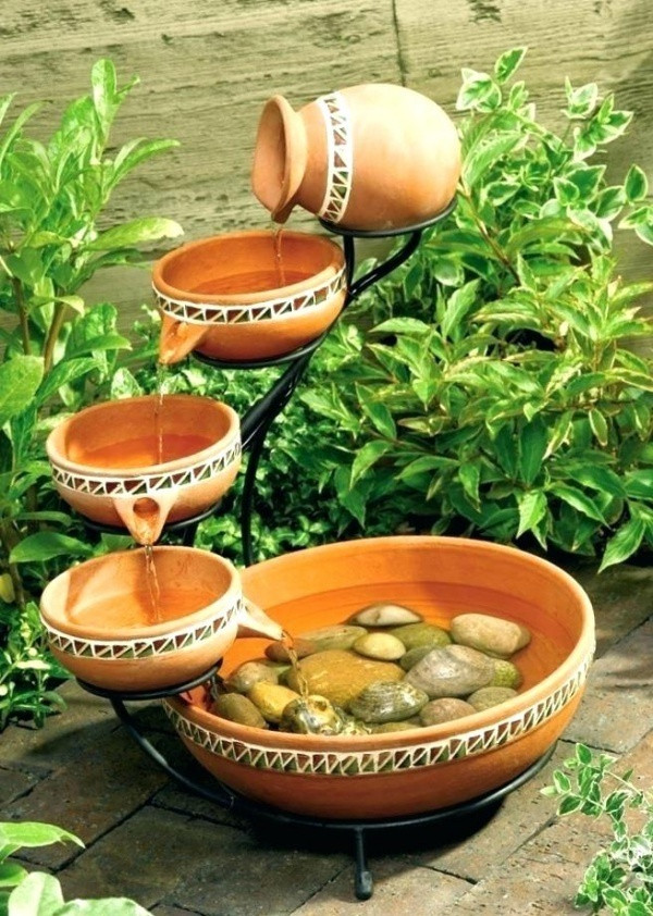 Chọn một chiếc kệ nhỏ xinh xinh, chọn thêm những chiếc bát gốm có vòi rót nước, vài viên đá cuội ở bát cuối cùng là đủ để có thác nước mini tuyệt đẹp cho góc sân nhỏ. Màu sắc của chất liệu gốm sẽ giúp không gian dịu dàng và gần gũi trong những ngày hè.