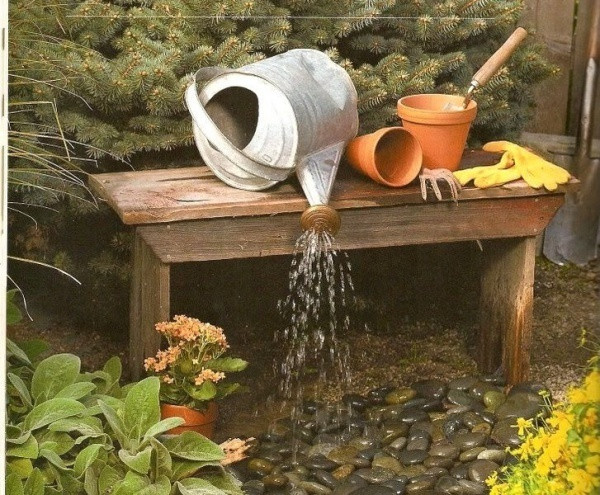 Dụng cụ tưới cây được decor đầy duyên dáng khi đặt nằm trên chiếc ghế cũ, mộc mạc và sờn màu theo thời gian. Đặt vòi nước vào bên trong, những viên đá cuội bên dưới là đủ đẻ có góc nhỏ đầy nghệ thuật và ấn tượng trong vườn vào mùa hè.