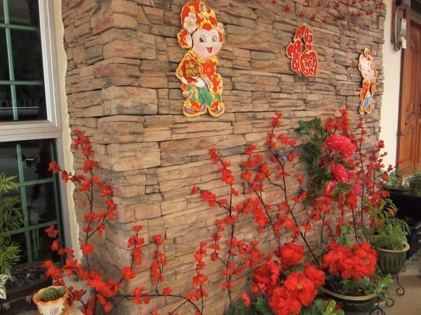 Dán những hình thù ngộ nghĩnh, dán chữ Phúc ở lối vào nhà, trang trí thêm hoa màu đỏ đơn giản nhưng vẫn đủ để rước lộc vào nhà trong năm mới.