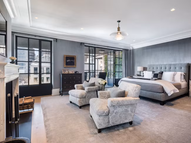 Phòng ngủ chính của căn hộ cũng có một lò sưởi, quầy bar, tủ quần áo lớn và cửa gỗ kiểu Pháp mở ra sân hiên.