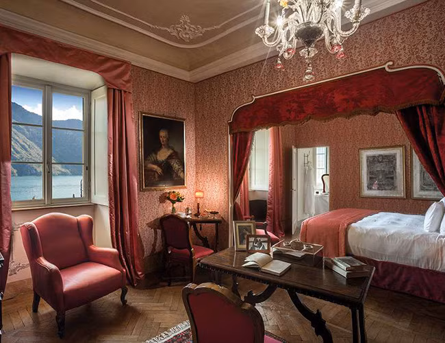 Các phòng ngủ được trang trí lộng lẫy với đèn chùm và tông màu đỏ sang trọng.