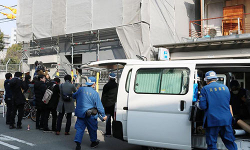 Cảnh sát và truyền thống đứng bên ngoài căn hộ ở Osaka, Nhật Bản.