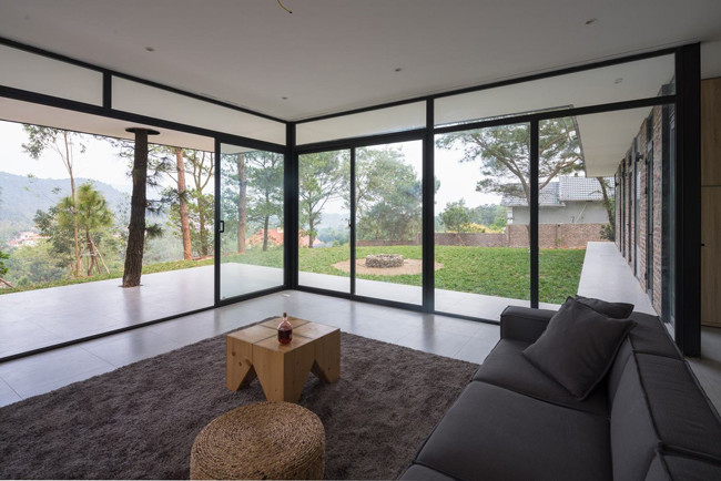 Khối phòng khách và phòng ngủ vuông góc, tạo thành một khoảng sân cỏ rộng rãi, bằng phẳng trước hiên nhà làm chỗ chơi cho lũ trẻ mà không làm cản trở tầm nhìn từ bên trong. Hầu hết các bức tường đều có cửa kính lớn, giúp lan tỏa ánh sáng tự nhiên môt cách tốt nhất.