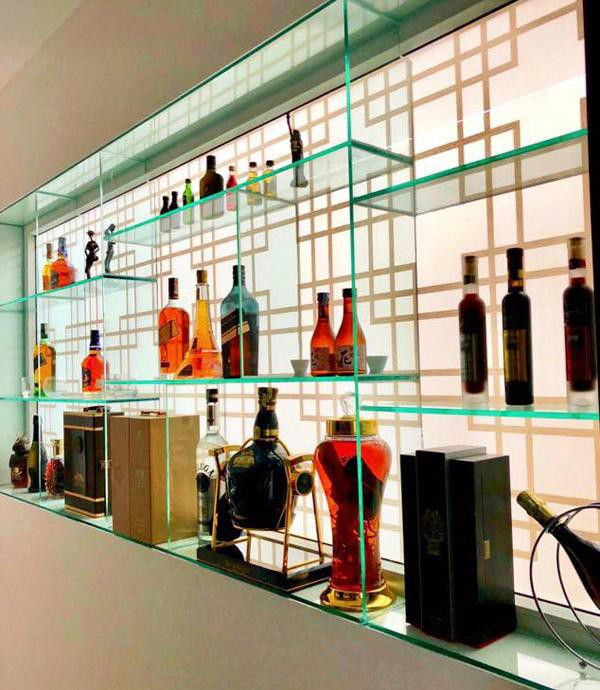 Tủ bày rượu được bà xã Quyền Linh "một tay thiết kế" đơn giản nhưng đẹp mắt. Dạ Thảo chia sẻ, chị tận dụng góc cửa sổ âm tường, tự vẽ theo ý mình rồi nhờ tiệm kính cường lực cắt kính và lắp ráp vào.