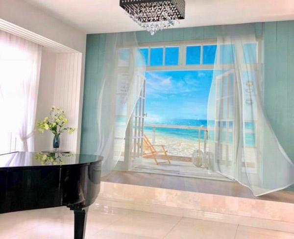 Góc chơi đàn được vẽ thêm khung cửa nhìn ra biển nên trông rất rộng và thơ mộng. "Vừa chơi đàn vừa ngắm biển... nhân tạo" - Dạ Thảo vui vẻ cho biết.