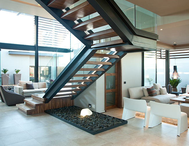 Cầu thang chắc chắn, đảm bảo an toàn khi di chuyển lên xuống cho gia đình. Chiếc ghế sofa màu trắng thanh lịch, phù hợp với phong cách trang trí của căn nhà.