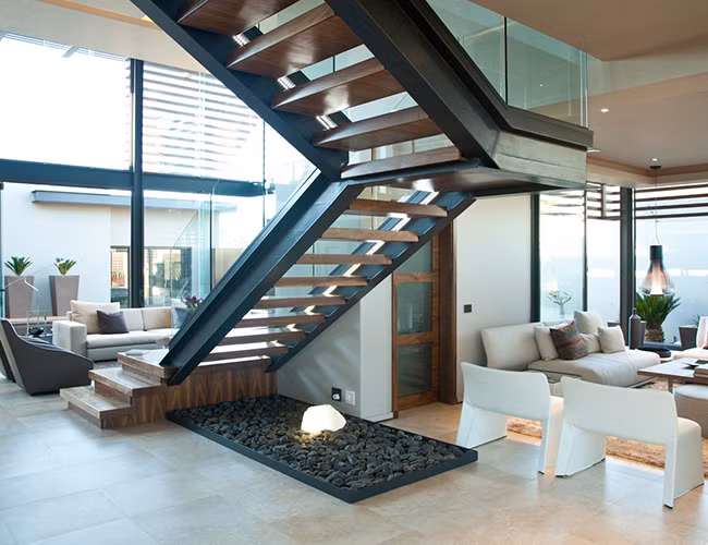 Cầu thang chắc chắn, đảm bảo an toàn khi di chuyển lên xuống cho gia đình. Chiếc ghế sofa màu trắng thanh lịch, phù hợp với phong cách trang trí của căn nhà.