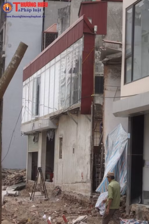 Theo cán bộ thanh tra xây dựng phường Dịch Vọng, tuyến đường dài chừng 700m đang được khẩn trương thi công và đã xuất hiện khoảng 6 – 7 ngôi nhà siêu mỏng, siêu méo. Theo quan sát của PV, những ngôi nhà siêu mỏng siêu méo này được gia chủ tu sửa lại rồi đóng cửa im lìm. Có ngôi nhà hình thù như một chuồng cọp, có ngôi nhà thì dài và nhìn đằng xa như một bức tường, được gia chủ gắn cánh cửa vào để đó, trông rất kỳ dị.