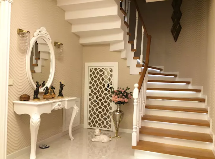 6. Trang trí dưới cầu thang với tủ gương Để không gian bên dưới cầu thang không trống trải, bạn có thể đặt một chiếc tủ nhỏ, bàn hoặc gương. Điều này không chỉ làm đẹp cho không gian nhà bạn mà còn giúp nó có thêm chức năng hữu ích.