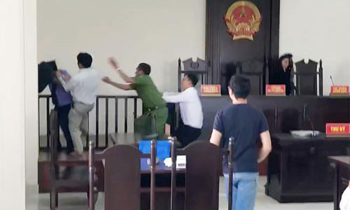 Ông Nguyễn Văn Hiền đấm vào mặt kiểm sát viên tại phòng xử án TAND huyện Bình Chánh, TP HCM. Ảnh: LÊ PHONG