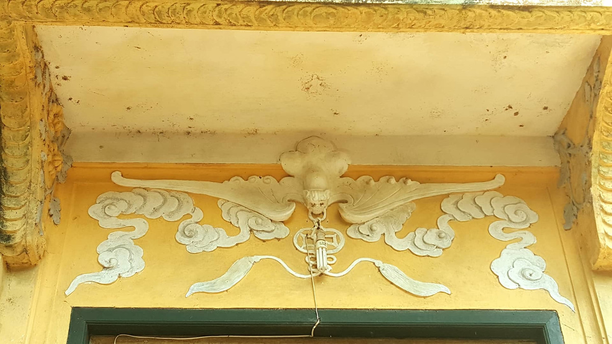 Phía ngoài cửa chính là phù điêu hình con dơi ngậm đồng tiền. Hình ảnh này mang ý nghĩa "Phúc lộc song toàn".