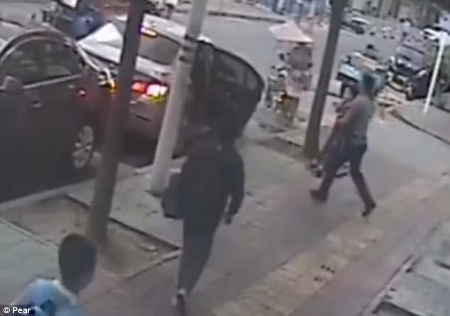 Cậu bé bị bế vào ô tô và ngơ ngác không hiểu chuyện gì.