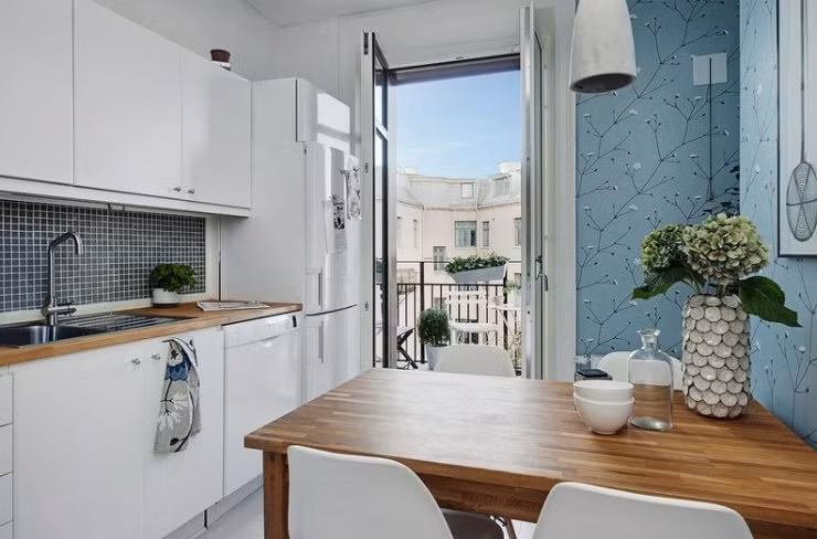 Căn bếp nhỏ bé mà đầy đủ tiện nghi. Tấm backsplash lát gạch gốm sứ màu xám tạo sự tương phản với tủ bếp trắng.