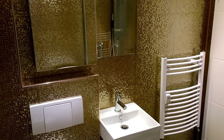 Phòng tắm được bao phủ bởi lớp gạch vàng rực rỡ tạo thêm phần lãng mạn cho căn hộ.