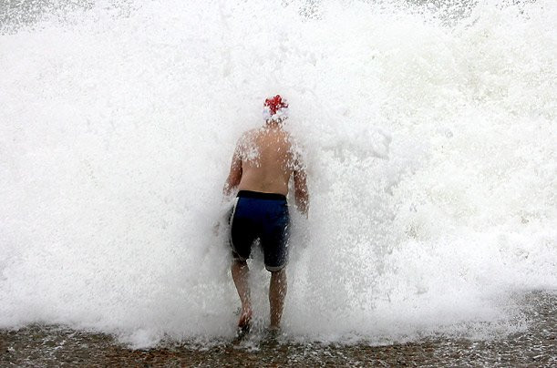 Mặc quần đùi và đội một chiếc mũ đỏ của ông già Noel rồi chạy xuống biển nô đùa với những con sóng là cách đón Giáng sinh rất riêng của những người đàn ông ở Brighton, Anh.