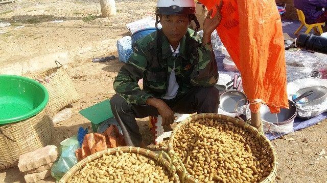 Người đàn ông chở lạc từ huyện Thuận Châu (Cách Tp.Sơn La hơn 40km) xuống khu chợ này với hi vọng sẽ bán được giá cao hơn 1 chút. Trời nắng nóng nhưng anh vẫn đội chiếc mũ bảo hiểm trên đầu và lấy tạm chiếc bao tải đựng lạc để làm “bình phong” che nắng.