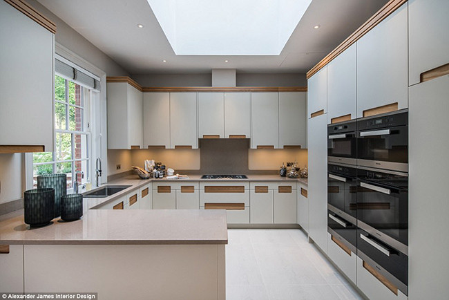 Nhà bếp với bộ tủ bếp mầu xám trung tính sang trọng với các cánh tủ đều bọc da. Ngoài ra phòng bếp rộng rãi và tràn ngập ánh sáng thiên nhiên này còn chứa một bàn ăn sáng lớn.