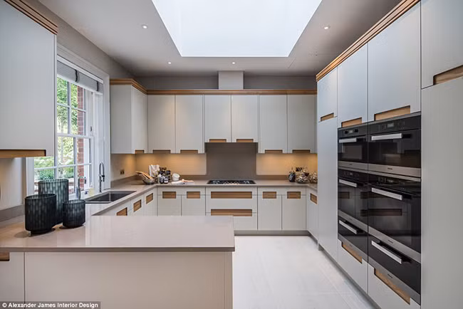 Nhà bếp với bộ tủ bếp mầu xám trung tính sang trọng với các cánh tủ đều bọc da. Ngoài ra phòng bếp rộng rãi và tràn ngập ánh sáng thiên nhiên này còn chứa một bàn ăn sáng lớn.