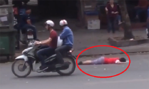 Người qua đường chỉ hướng ánh mắt tò mò về phía nạn nhân rồi lại rảo bước tiếp tục hành trình của mình. Ảnh cắt từ clip.