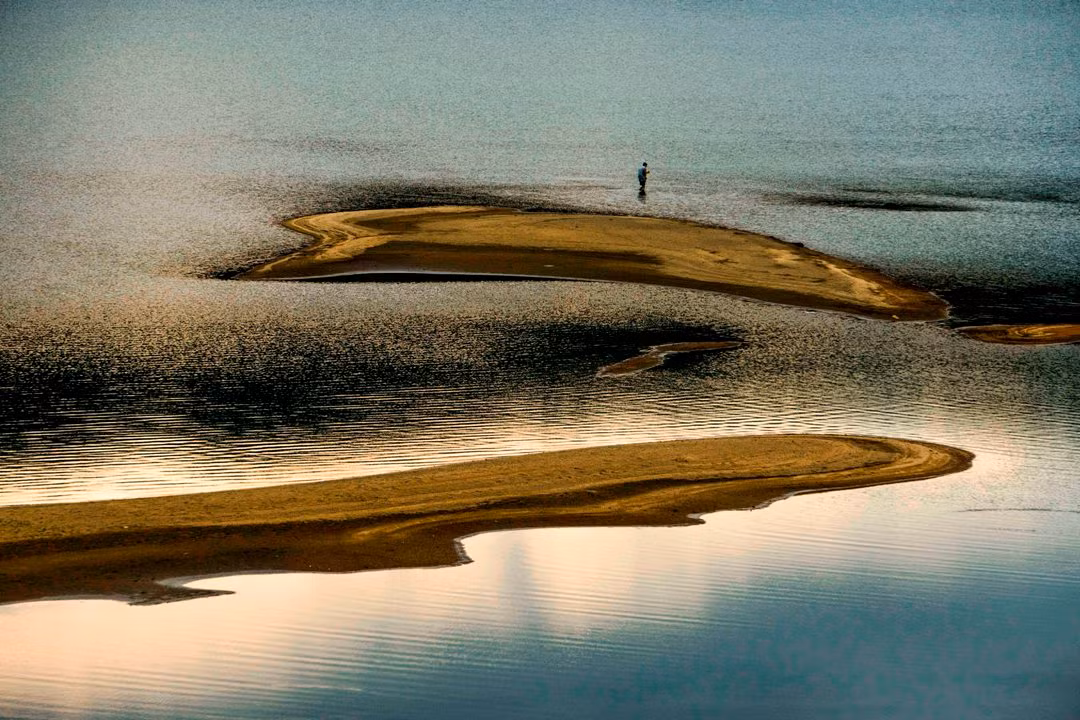 Nước cạn, người dân ở lòng hồ không cần dùng thuyền, chỉ lội bộ cũng có thể thả được lưới để bắt cá.