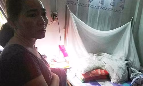 Bà Tuyết bị kẻ cướp dùng dao khống chế khi đang nằm trên giường. Ảnh: Nạn nhân cung cấp.