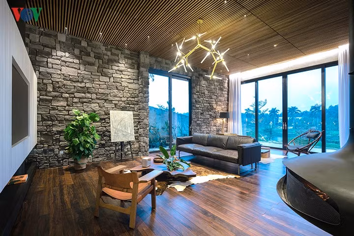 Phòng sinh hoạt chung trên tầng 2 với chất liệu đá mộc mạc. Ở giữa phòng có một lò sưởi để sử dụng phù hợp với khí hậu lạnh miền bắc.