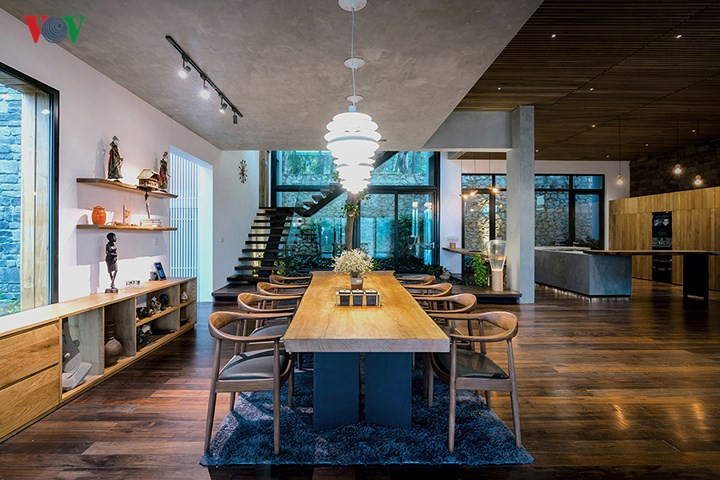 Tầng 1 là một không gian liên hoàn, với phòng khách, phòng bếp, phòng ăn và khu vực cầu thang. Phía trên bàn ăn là trần bê tông thô mộc. Đây là đáy bể bơi trên tầng 2.