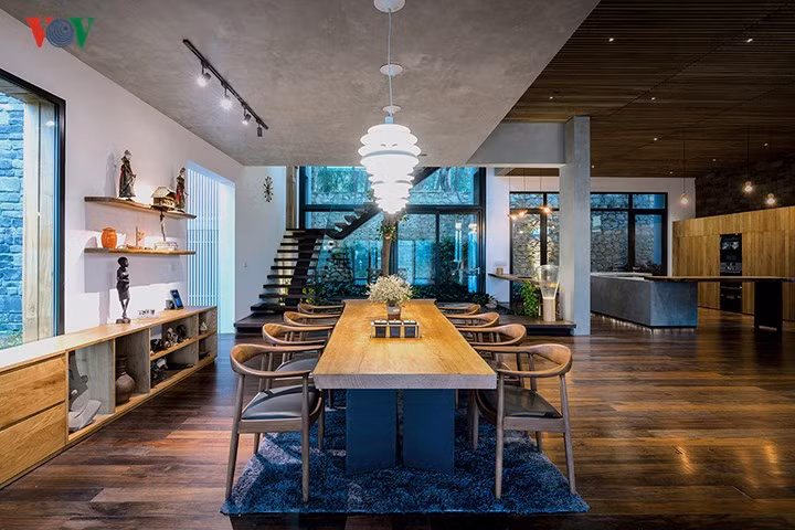 Tầng 1 là một không gian liên hoàn, với phòng khách, phòng bếp, phòng ăn và khu vực cầu thang. Phía trên bàn ăn là trần bê tông thô mộc. Đây là đáy bể bơi trên tầng 2.