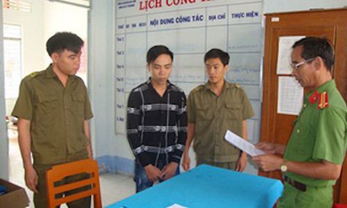 Cán bộ điều tra tống đạt quyết định khởi tố bị can, bắt tạm giam đối với Linh. Ảnh: C.A.