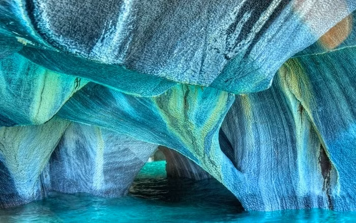 Hang động đá cẩm thạch (Chile) 6.000 năm trước, những đợt sóng dội vào và làm xói mòn những phiến đá, tạo nên hang động đá cẩm thạch kỳ thú. Bạn có thể chèo thuyền kayak và chiêm ngưỡng vẻ đẹp những cái hang sâu này, phản chiếu lại nước hồ Carrera màu xanh lam tuyệt đẹp.